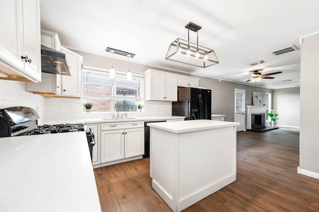 17203 Kettle Creek Dr, Spring, TX 77379 - kitchen with black fridge, range hood, dishwasher, decorative backsplash, and a kitchen island