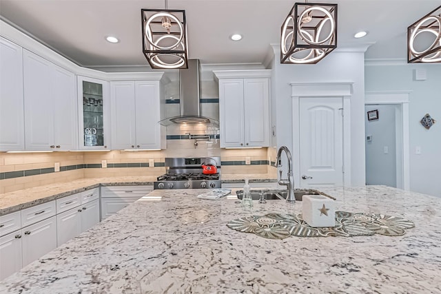 6 Caravelle Ct, Galveston, TX 77554 - kitchen featuring stainless steel gas range oven, wall chimney range hood, white cabinetry, crown molding, and glass insert cabinets