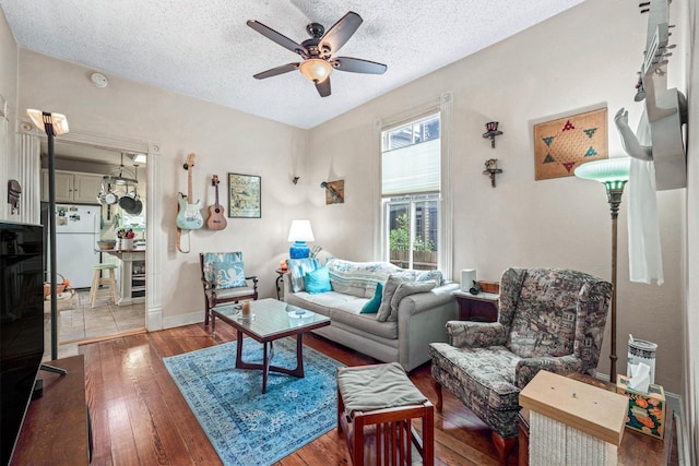 1611 34th St, Galveston, TX 77550 - living room featuring ceiling fan, a textured ceiling, and hardwood / wood-style flooring