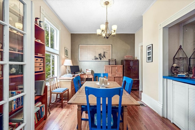 1611 34th St, Galveston, TX 77550 - dining room with a chandelier, hardwood / wood-style floors, and a textured ceiling