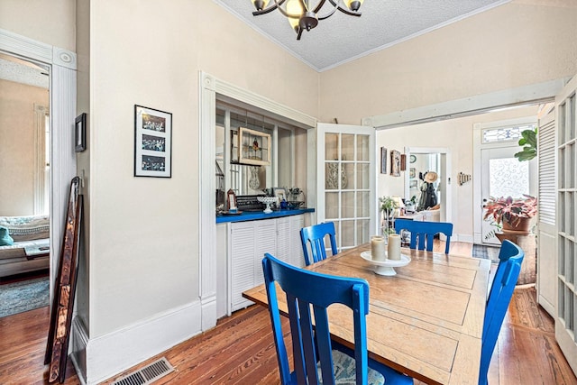 1611 34th St, Galveston, TX 77550 - dining room featuring crown molding, a chandelier, wood finished floors, and a textured ceiling