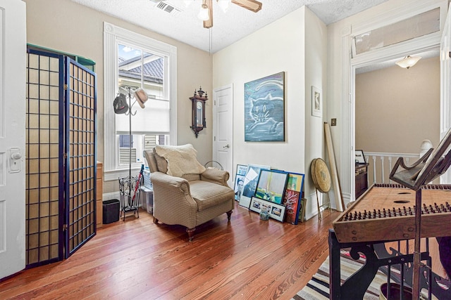 1611 34th St, Galveston, TX 77550 - living area featuring wood-type flooring, ceiling fan, and a textured ceiling