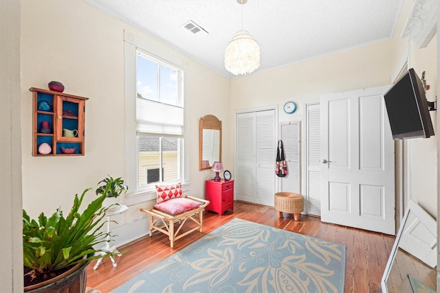 1611 34th St, Galveston, TX 77550 - living area featuring hardwood / wood-style flooring, a chandelier, and ornamental molding