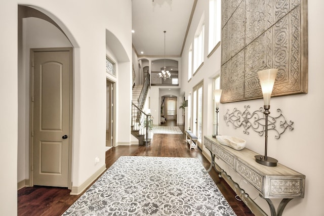 13810 Lake Prt, Cypress, TX 77429 - hallway featuring arched walkways, wood finished floors, stairs, a towering ceiling, and a chandelier