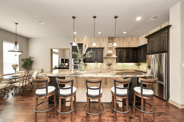 13810 Lake Prt, Cypress, TX 77429 - kitchen with appliances with stainless steel finishes, wall chimney exhaust hood, dark wood finished floors, light stone countertops, and a large island