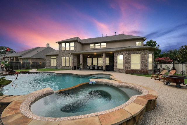 13810 Lake Prt, Cypress, TX 77429 - pool at dusk with a pool with connected hot tub, a patio, and a fenced backyard