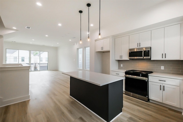 5703C Balbo St, Houston, TX 77091 - kitchen with appliances with stainless steel finishes, a center island, backsplash, light wood-type flooring, and light countertops