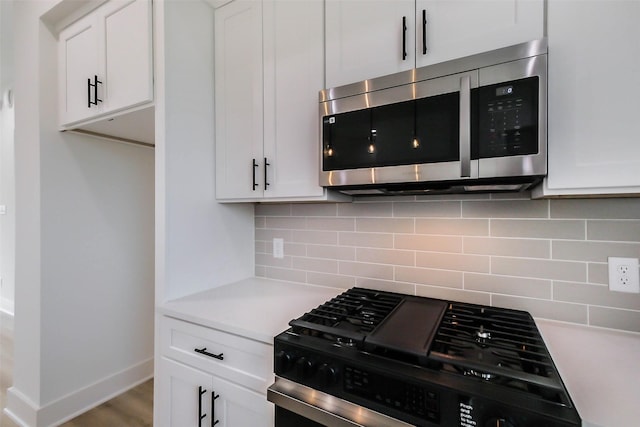 5703C Balbo St, Houston, TX 77091 - kitchen featuring gas range oven, stainless steel microwave, light countertops, and white cabinets