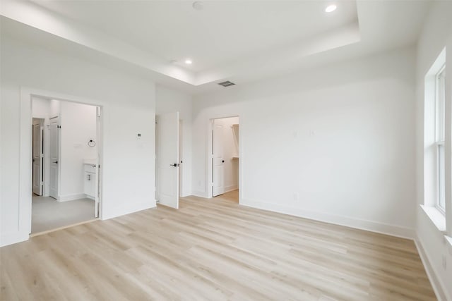 5703C Balbo St, Houston, TX 77091 - unfurnished bedroom with a tray ceiling, light wood-type flooring, recessed lighting, a spacious closet, and ensuite bath