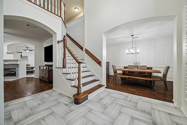 4107 Wentworth Dr, Fulshear, TX 77441 - entryway featuring arched walkways, ceiling fan, stairway, a glass covered fireplace, and a high ceiling