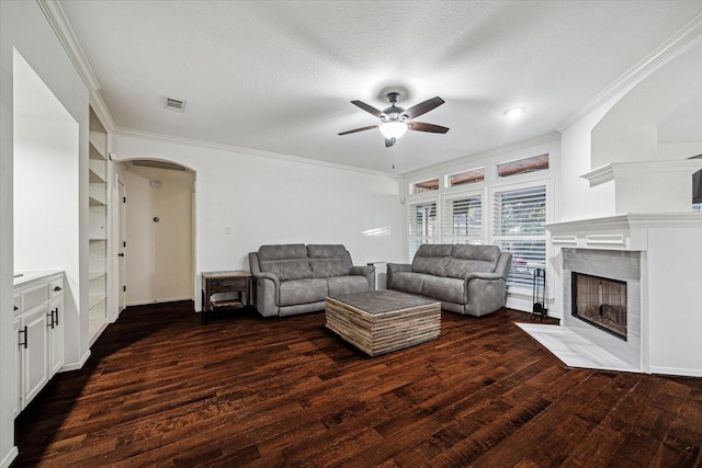 4107 Wentworth Dr, Fulshear, TX 77441 - living area featuring arched walkways, ceiling fan, crown molding, wood finished floors, and a fireplace with flush hearth