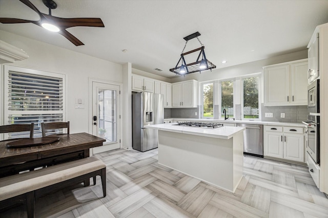 4107 Wentworth Dr, Fulshear, TX 77441 - kitchen with stainless steel appliances, light countertops, white cabinetry, a center island, and recessed lighting