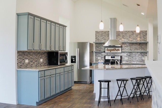 20367 Tembec Dr, New Caney, TX 77357 - kitchen with stainless steel appliances, extractor fan, gray cabinetry, backsplash, and high vaulted ceiling