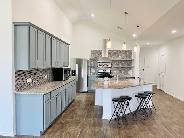 20367 Tembec Dr, New Caney, TX 77357 - kitchen featuring wall chimney exhaust hood, appliances with stainless steel finishes, gray cabinets, tasteful backsplash, and high vaulted ceiling