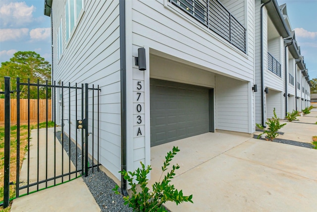 5703E Balbo St, Houston, TX 77091 - view of side of home featuring concrete driveway, a garage, and a gate