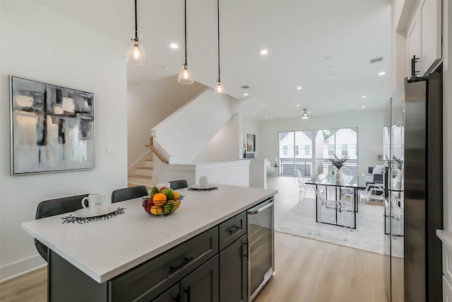 5703E Balbo St, Houston, TX 77091 - kitchen with light wood-style floors, light countertops, open floor plan, a center island, and decorative light fixtures