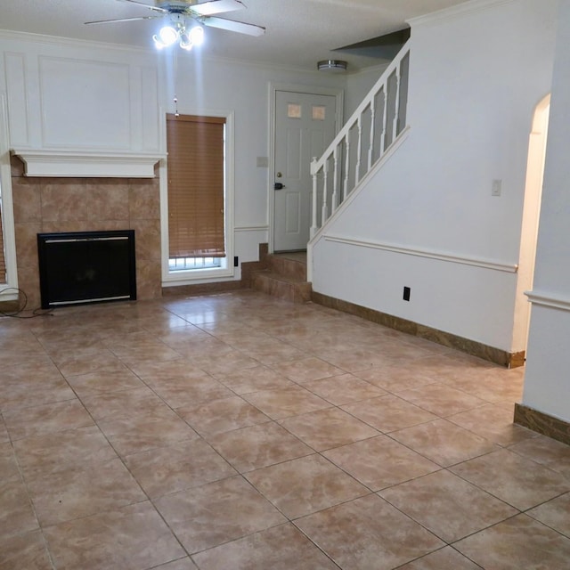 3600 Jeanetta St Unit 1301, Houston, TX 77063 - unfurnished living room with ceiling fan, crown molding, stairway, light tile patterned floors, and a tile fireplace