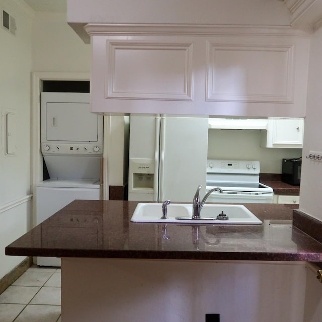 3600 Jeanetta St Unit 1301, Houston, TX 77063 - kitchen with white appliances, stacked washer / dryer, white cabinets, custom range hood, and light tile patterned floors