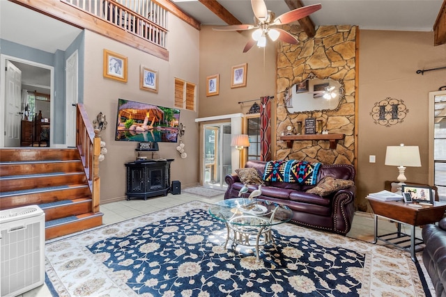 11505 US Highway 190 W, Livingston, TX 77351 - living area featuring ceiling fan, a wood stove, tile patterned floors, beam ceiling, and stairs