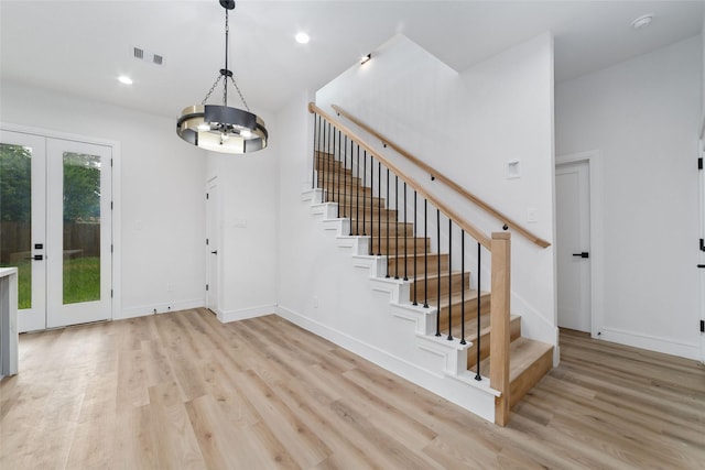 6715 England St, Houston, TX 77021 - staircase featuring wood finished floors, french doors, a chandelier, and recessed lighting