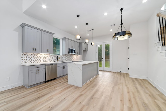 6715 England St, Houston, TX 77021 - kitchen featuring stainless steel appliances, gray cabinets, light wood-style flooring, decorative backsplash, and recessed lighting