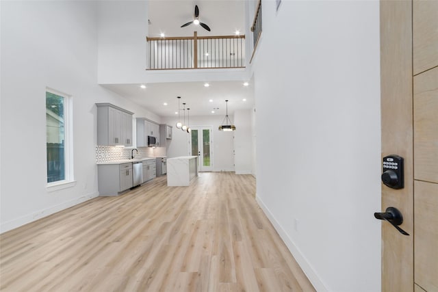 6715 England St, Houston, TX 77021 - unfurnished living room with a ceiling fan, light wood finished floors, a towering ceiling, and recessed lighting
