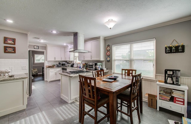 9818 Emnora Ln, Houston, TX 77080 - dining area with ornamental molding, a textured ceiling, light tile patterned floors, a wainscoted wall, and recessed lighting