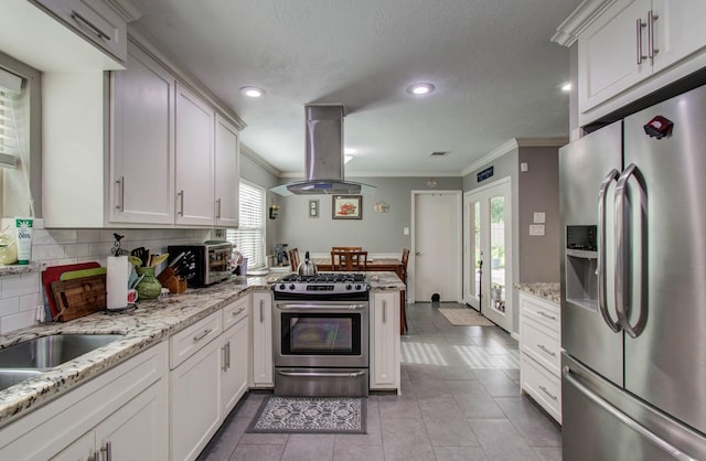 9818 Emnora Ln, Houston, TX 77080 - kitchen with stainless steel appliances, island range hood, crown molding, a peninsula, and decorative backsplash