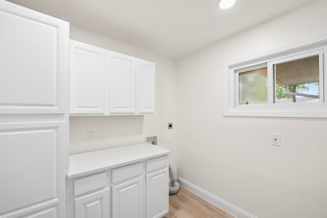 3815 Latma Dr, Houston, TX 77025 - laundry room with hookup for an electric dryer, cabinet space, and light wood finished floors