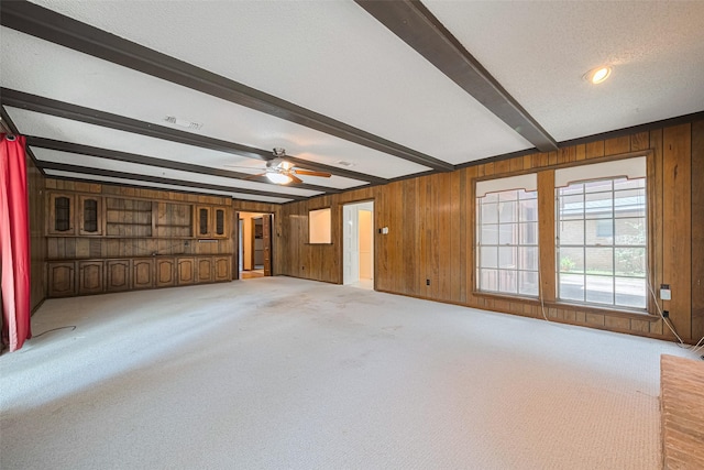 2823 W Pebble Beach Dr, Missouri City, TX 77459 - unfurnished living room featuring beam ceiling, wooden walls, carpet, and ceiling fan