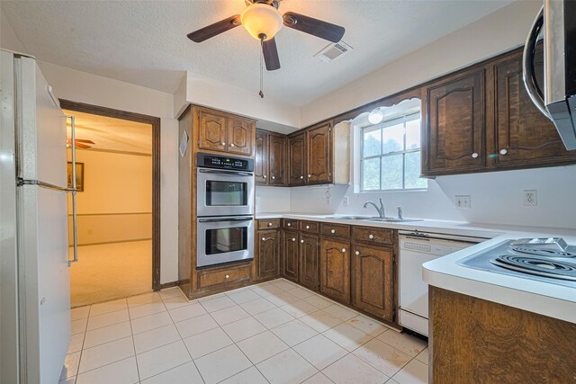 2823 W Pebble Beach Dr, Missouri City, TX 77459 - kitchen with white appliances, light countertops, ceiling fan, light tile patterned floors, and dark brown cabinetry