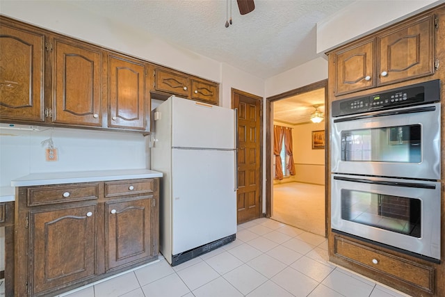 2823 W Pebble Beach Dr, Missouri City, TX 77459 - kitchen featuring freestanding refrigerator, double oven, ceiling fan, light countertops, and light tile patterned floors