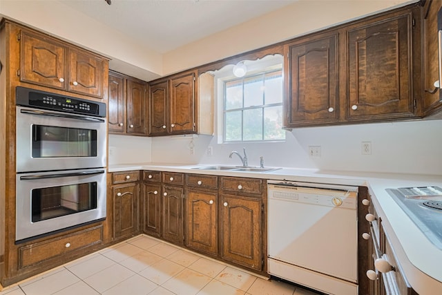 2823 W Pebble Beach Dr, Missouri City, TX 77459 - kitchen with stainless steel double oven, dishwasher, light countertops, and light tile patterned floors