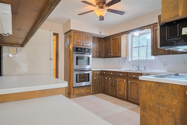 2823 W Pebble Beach Dr, Missouri City, TX 77459 - kitchen featuring stainless steel double oven, light tile patterned floors, a ceiling fan, light countertops, and freestanding refrigerator