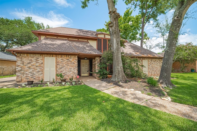 2823 W Pebble Beach Dr, Missouri City, TX 77459 - view of front of home featuring roof with shingles, a front lawn, and brick siding