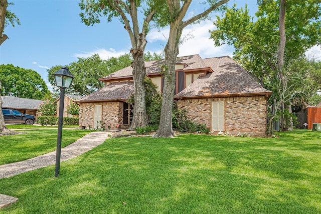 2823 W Pebble Beach Dr, Missouri City, TX 77459 - view of front facade featuring brick siding, a front yard, and roof with shingles