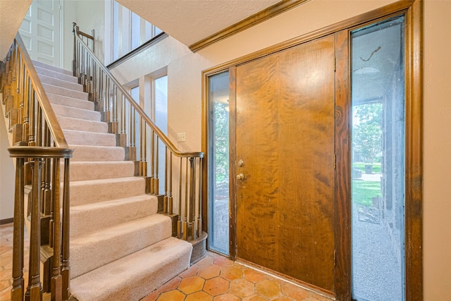 2823 W Pebble Beach Dr, Missouri City, TX 77459 - entrance foyer with stairs, light tile patterned floors, and crown molding
