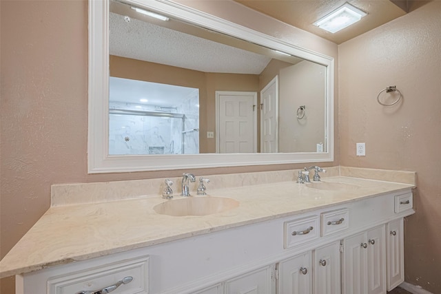 2823 W Pebble Beach Dr, Missouri City, TX 77459 - bathroom featuring a textured wall, double vanity, and a shower