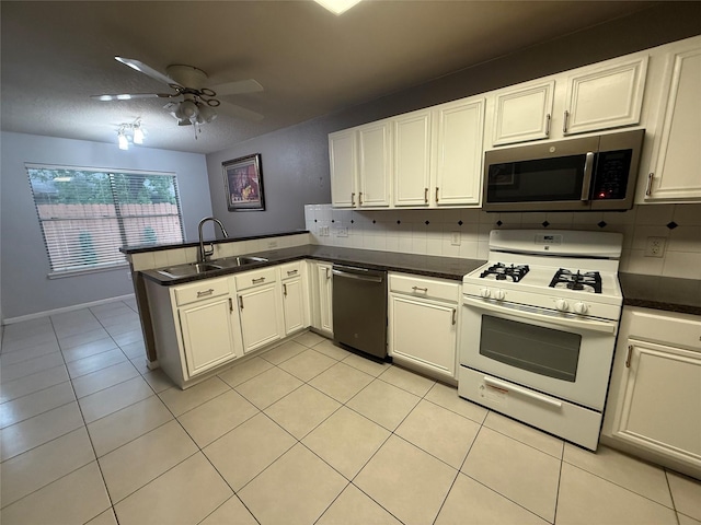 13202 Chasworth Dr, Houston, TX 77041 - kitchen with stainless steel appliances, a peninsula, ceiling fan, light tile patterned floors, and dark countertops