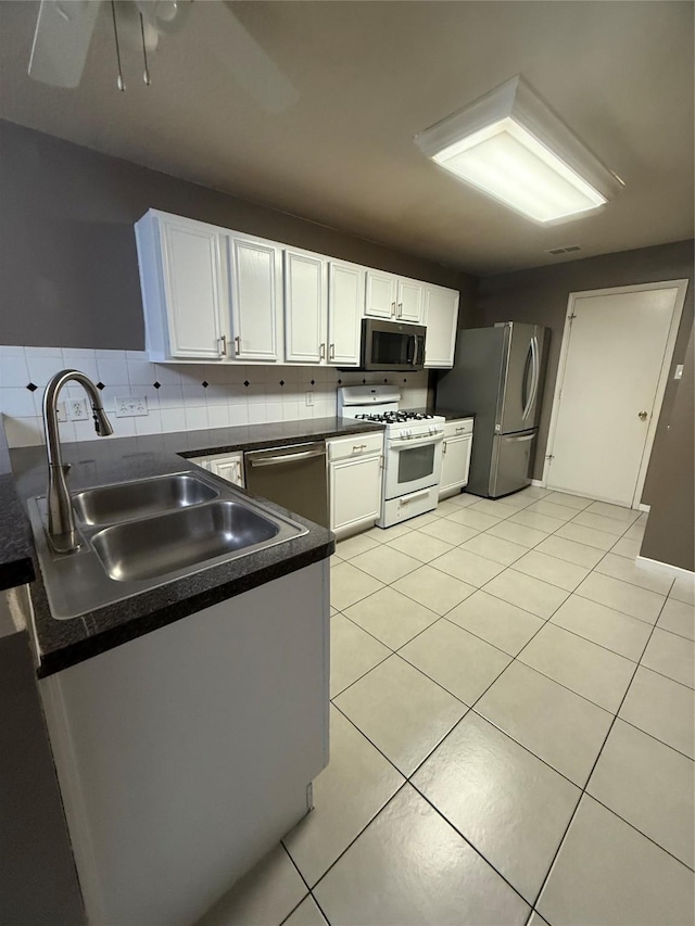 13202 Chasworth Dr, Houston, TX 77041 - kitchen with appliances with stainless steel finishes, dark countertops, white cabinets, and light tile patterned floors