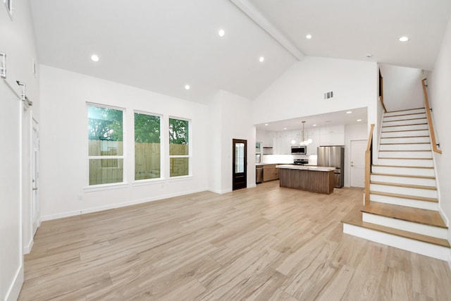 3907 Sumpter St, Houston, TX 77020 - unfurnished living room with high vaulted ceiling, light wood finished floors, beam ceiling, stairs, and recessed lighting