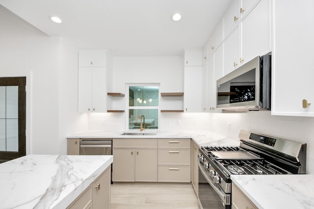 3907 Sumpter St, Houston, TX 77020 - kitchen featuring appliances with stainless steel finishes, open shelves, backsplash, light stone countertops, and light wood-style flooring