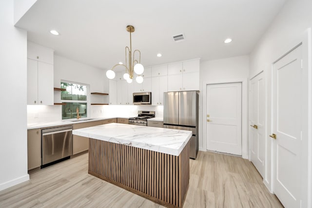 3907 Sumpter St, Houston, TX 77020 - kitchen with stainless steel appliances, open shelves, light wood-type flooring, white cabinetry, and recessed lighting