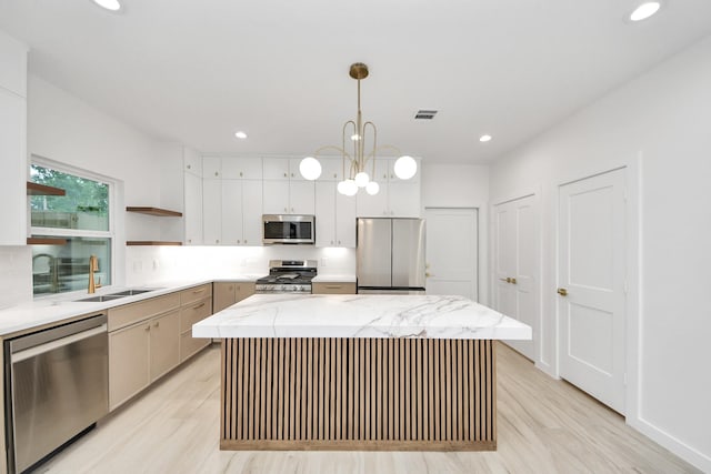 3907 Sumpter St, Houston, TX 77020 - kitchen featuring stainless steel appliances, open shelves, a kitchen island, light wood-type flooring, and recessed lighting