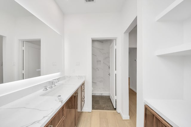 3907 Sumpter St, Houston, TX 77020 - bathroom with vanity, a marble finish shower, and wood finished floors