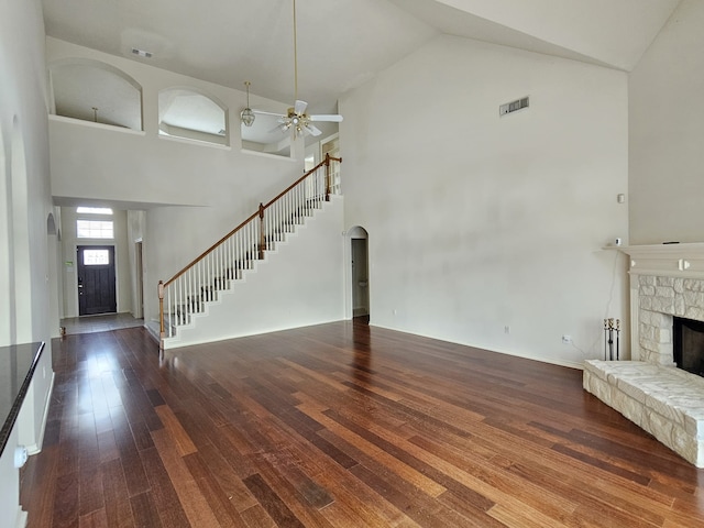 8123 Cove Timbers Ln, Tomball, TX 77375 - unfurnished living room with high vaulted ceiling, a ceiling fan, a fireplace, wood finished floors, and stairway