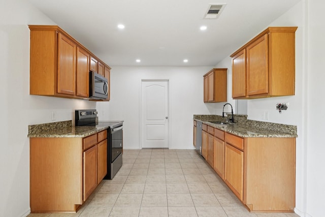2607 Ensbrook Meadow Ln, Katy, TX 77449 - kitchen featuring appliances with stainless steel finishes, dark stone countertops, recessed lighting, brown cabinets, and light tile patterned flooring