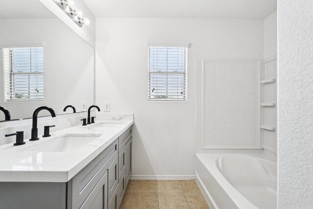 2607 Ensbrook Meadow Ln, Katy, TX 77449 - full bathroom with double vanity, a bathtub, healthy amount of natural light, and tile patterned floors