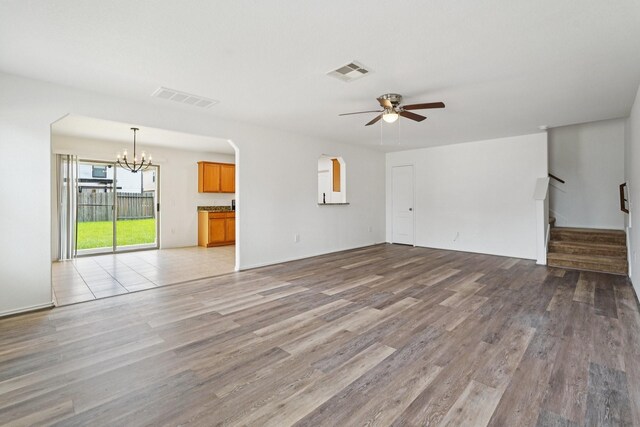 2607 Ensbrook Meadow Ln, Katy, TX 77449 - unfurnished living room featuring a chandelier, a ceiling fan, light wood-type flooring, and stairs