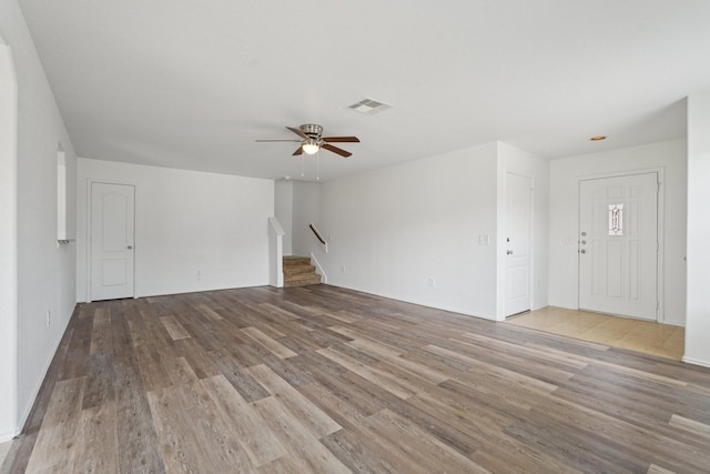 2607 Ensbrook Meadow Ln, Katy, TX 77449 - unfurnished living room featuring wood finished floors, a ceiling fan, and stairs